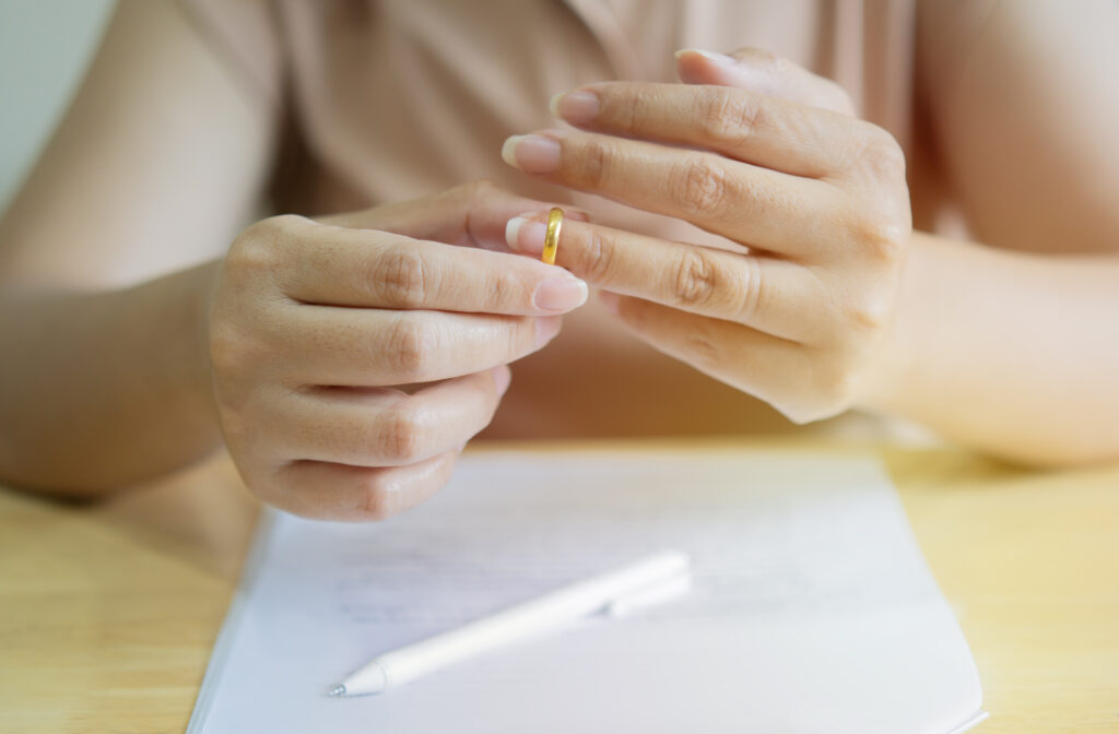 A woman is removing her wedding ring.